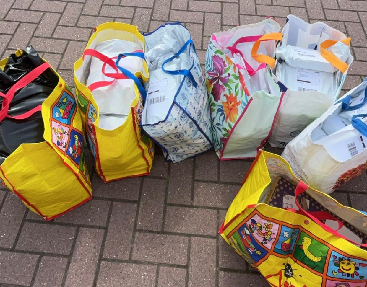 Verschillende gele, zwarte en bloemen tassen vol met pakketjes ProstecWear voetbalaccessoires
