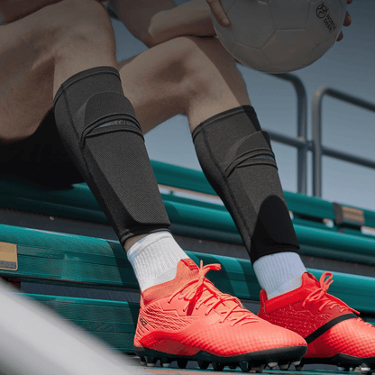 Voetballer draagt zwarte Prostec Scheenbeschermer Sleeves met hexagonale bescherming, belangrijke voetbalaccessoires